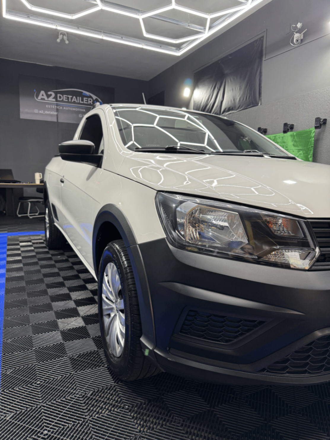 Picape branca com pintura renovada em box de estética automotiva