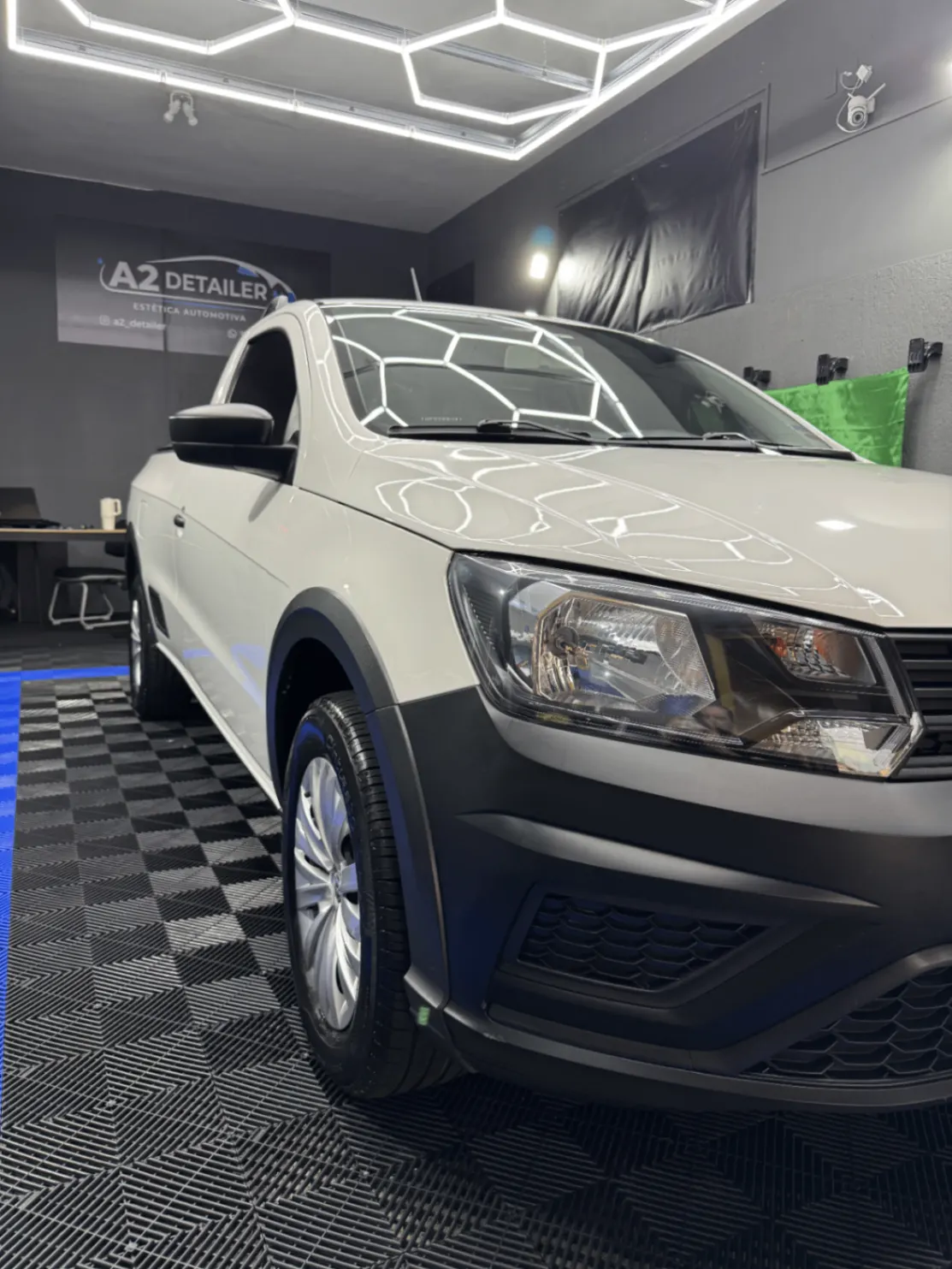 Picape branca com pintura renovada em box de estética automotiva